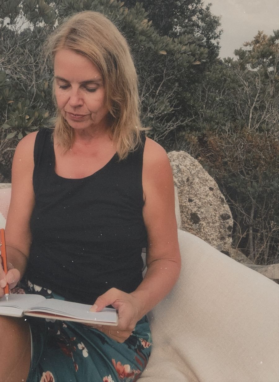 Elke Bayer writing in a journal outdoors